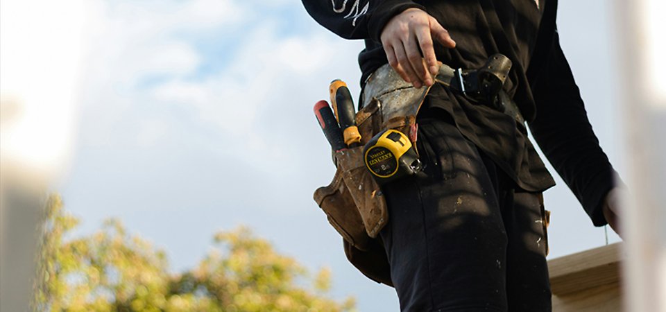 Kille med byggkläder och verktyg på sig.